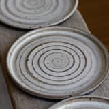 Small plate in black speckled clay with a white glaze
