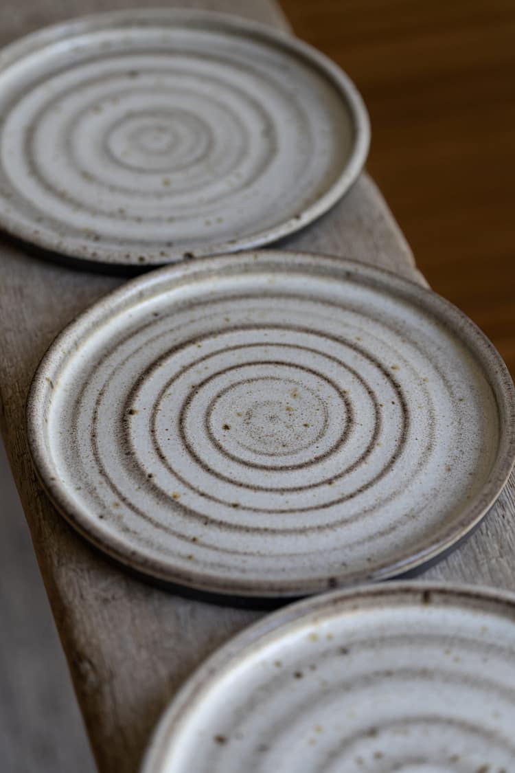 Small plate in black speckled clay with a white glaze